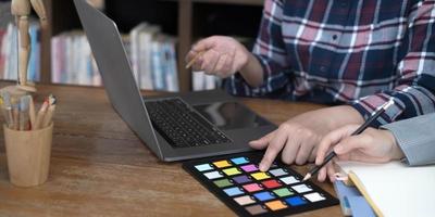 ontwerper grafisch creatieve creativiteit samenwerken kleuren met behulp van grafisch tablet en een stylus aan bureau met collega foto