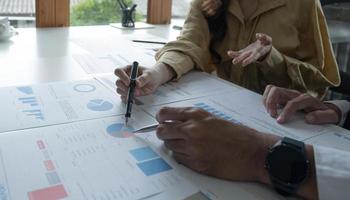 zakelijke teamondersteuning en vergaderconcept. groep investeerders die werken en wijzen op de financiële taak van het financiële papierwerk. foto