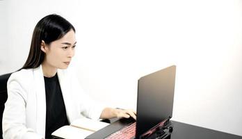 gelukkige tevreden aziatische vrouw rust thuis kantoor zitten met laptop na klaar werk voel vrede en ontspan. foto