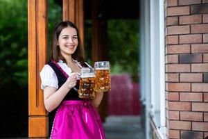 sexy Russische vrouw in Beierse jurk met bierpullen. foto