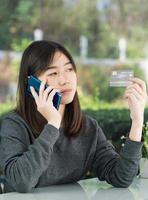 jonge vrouw met creditcard en smartphone foto
