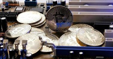gouden munten met bitcoin-symbool op elektronische schakelingen in een computer moederbord. foto