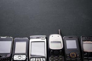 oude en verouderde mobiele telefoons op een zwarte achtergrond. foto