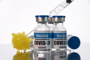 glazen flesjes voor covid-19 vaccin op witte achtergrond. groep coronavirusvaccinflessen. foto