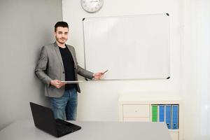 jonge zakenman of leraar met gegevens op wit bord