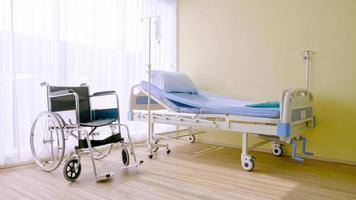 ziekenhuisbed en rolstoel in ziekenhuiskamer. foto