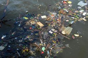 veel drijvend afval dat door mensen werd gegooid waardoor de rivier vies en vervuild werd. foto