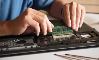 de ingenieur repareert de laptop en het moederbord. installeert de apparatuur foto