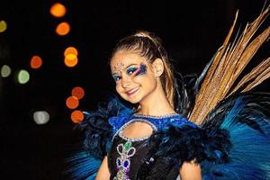 Braziliaanse tiener die sambakostuum draagt. mooie braziliaanse jongen vrouw dragen kleurrijke kostuum en glimlachen tijdens carnaval straatparade in brazilië. foto