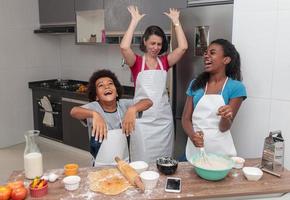 moeder en kinderen bereiden samen de lunch in de keuken. rommelige kinderen. foto