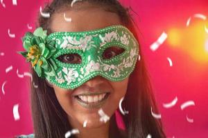 gelukkige jonge vrouw met masker en confetti op carnavalsfeest. braziliaans carnaval foto