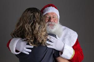 gelukkige kerstman knuffelen vrouw, dankbaarheid en liefde op kerstnacht. foto