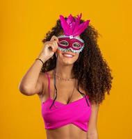 mooie vrouw gekleed voor carnaval nacht. lachende vrouw klaar om te genieten van het carnaval met een kleurrijk masker. foto