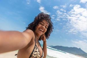 zwarte afro jong schattig meisje, krullend haar, bikini, strand. Afro-Amerikaanse zomervakantie vakantie. foto