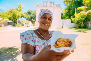 gelukkige braziliaanse vrouw gekleed in traditioneel bahiaans kostuum, in het historische centrum van porto seguro op de achtergrond foto