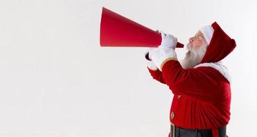 santa claus schreeuwen met behulp van megafoon op witte achtergrond. foto