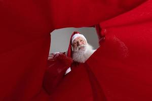 afbeelding van binnenuit de zak, de kerstman stopt geschenken in de zak. foto