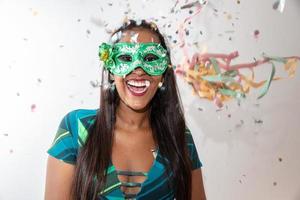 gelukkige jonge vrouw met masker en confetti op carnavalsfeest. braziliaans carnaval foto