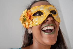 gelukkige jonge vrouw met masker en confetti op carnavalsfeest. braziliaans carnaval foto