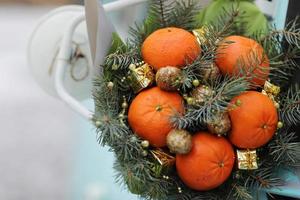 kerstboeket van dennentakken, mandarijnen en kleine geschenkdozen op blauwe achtergrond. Nieuwjaar. foto