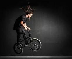 jonge sportman die stunts doet op zijn professionele fiets. foto