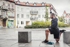 man strekt zijn benen in de stad foto