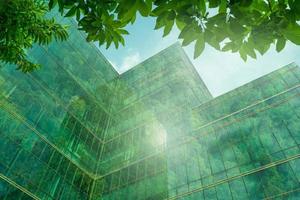 milieuvriendelijk gebouw in de moderne stad. duurzaam glazen kantoorgebouw met boom voor het verminderen van warmte en kooldioxide. kantoorgebouw met groene omgeving. bedrijfsgebouw verminderen co2. foto