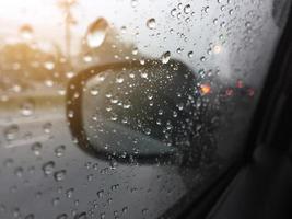 waterdruppels op een raam in de zware regen. weergave van auto op straat. foto