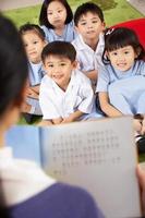 leraar lezen aan studenten in de klas van de Chinese school foto