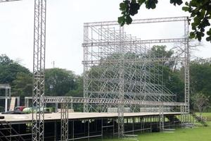 verschillende delen van metalen steiger op het bouwveld. arbeiders bouwen een concertpodium. podium apparatuur. foto