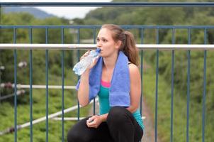 jonge vrouw die gebotteld water drinkt