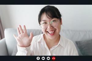 portret gelukkige vrouw die thuis werkt door videoconferentievergadering zwaaiend met de hand, pratend en kijkend naar de camera. groet familie of vrienden foto