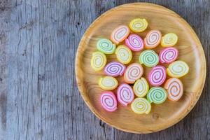 kleurrijke gummy snoep op houten schotel en op houten achtergrond. kopieer ruimte achtergrond en textuur foto