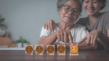 oma en kleindochter wijzen met de vingers naar de houten blokken die op tafel liggen foto