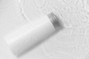 witte fles flacon cosmetica schoonheidsproduct voor huidverzorging gezichtscrème en bodylotion douchegel natuurlijke organische cosmetologie in waterdruppel puur mooi. foto