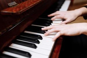 close-up van de handen van een jonge vrouw die piano speelt foto