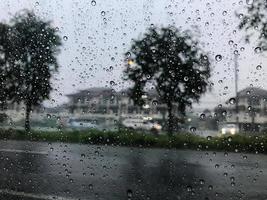 hevige regen en regendruppel op de autoruit moet de auto onderweg stoppen. voor de veiligheid van het rijden omdat ik de weg vooruit niet kan zien, kan dit tijdens het rijden een ongeluk veroorzaken. foto