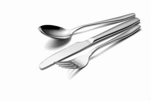de metalen glanzende lepel, vork en mes op een wit foto