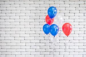 heldere kleurrijke ballonnen in de buurt van witte bakstenen muur foto