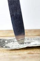 een Amerikaanse dollar doorboord met een mes foto