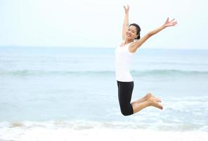juichende vrouw die op het strand springt. zomervakantie