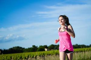 fitness sport gezonde en vrolijke jonge vrouw die openlucht loopt foto