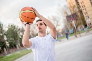 jonge man voorbereiden om een basketbal te schieten