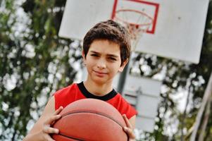 jongen speelt basketbal foto