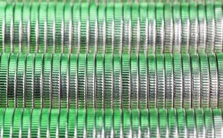 veel ronde metalen munten van zilverkleur verlicht in groen foto