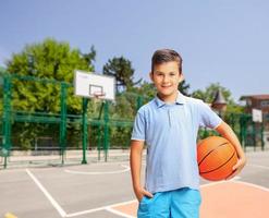 vrolijke jongen met een basketbal op een buitenbaan