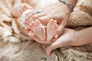 baby voeten in handen van de moeder. gelukkig gezin concept.