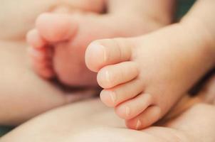 baby's voet in handen van de moeder foto