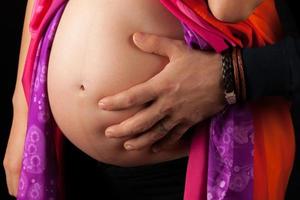 zwangere buik met mannenhand erop foto