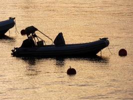 achtergrondverlichting van sportboten voor anker in een baai foto